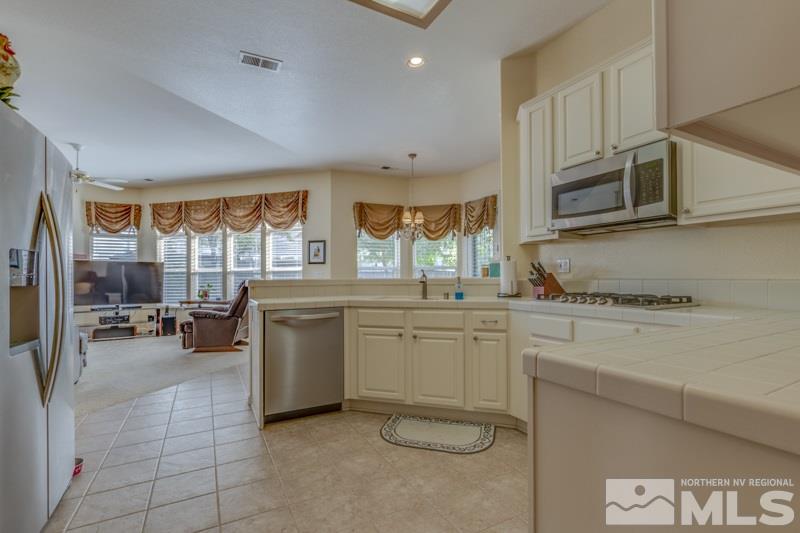 9960 Moccasin Court Reno, NV 89521 - Photo 5 of 20 a kitchen with stainless steel appliances granite countertop a stove a sink and a microwave