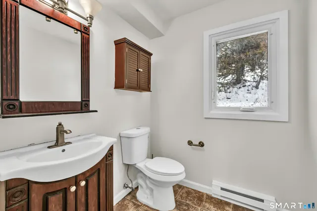 a bathroom with a toilet a sink and mirror