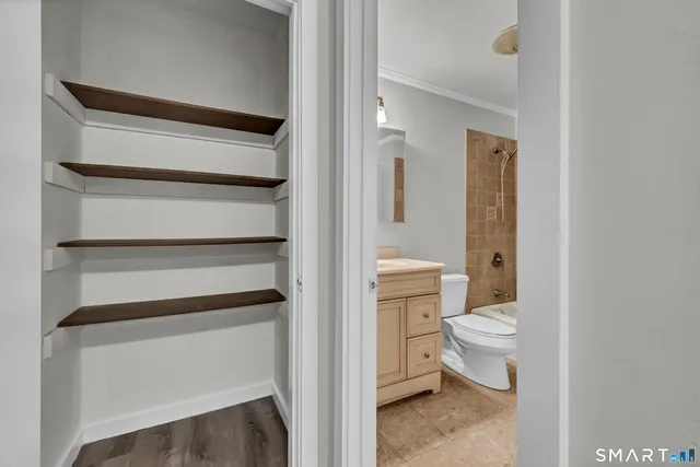 a bathroom with a sink a toilet a mirror and shower