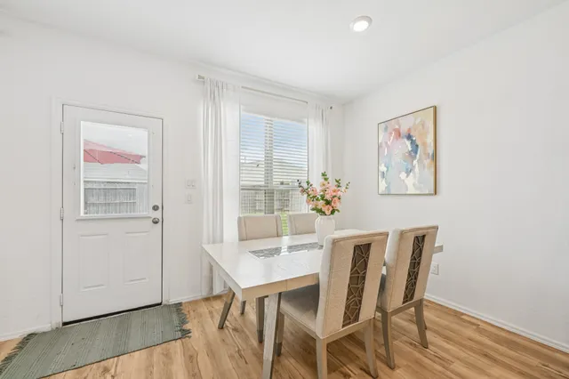 a living room with furniture and a dining table with wooden floor