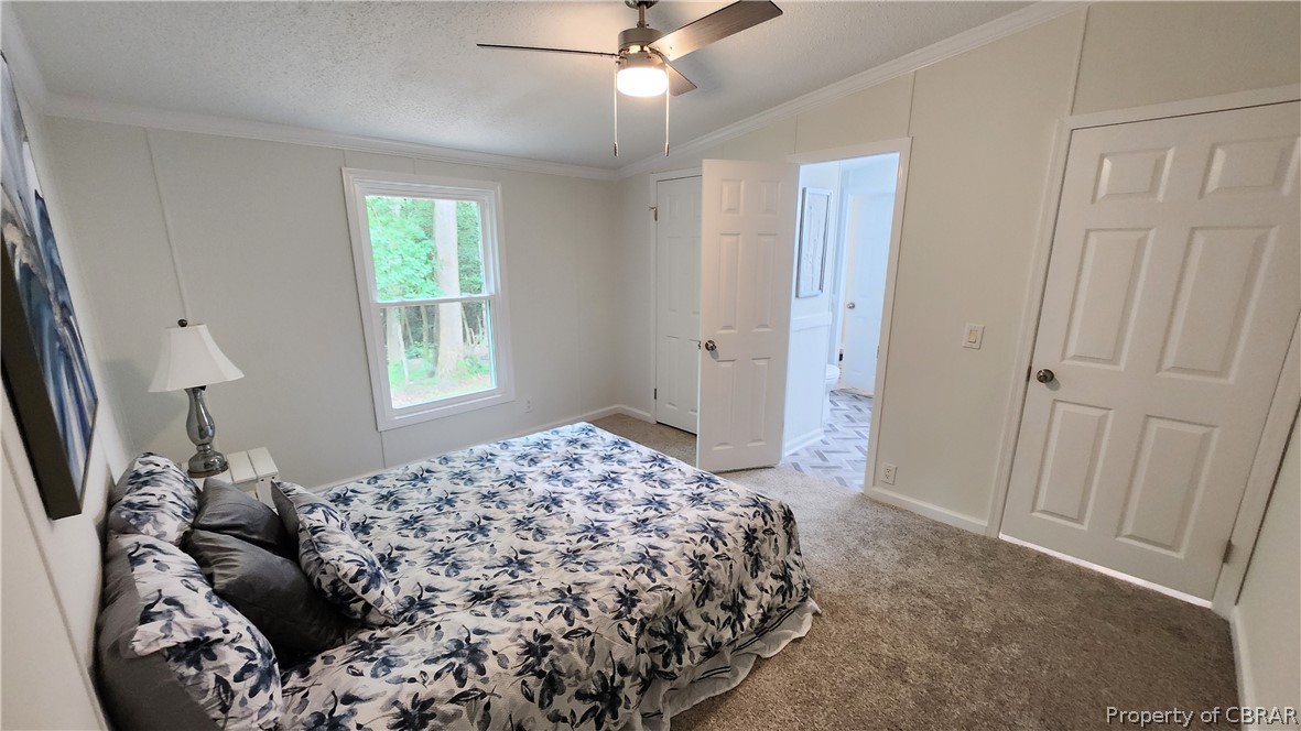 8065 Filly Run Road Gloucester, VA 23061 - Photo 28 of 33 Carpeted bedroom with ceiling fan, vaulted ceiling, a textured ceiling, and ornamental molding