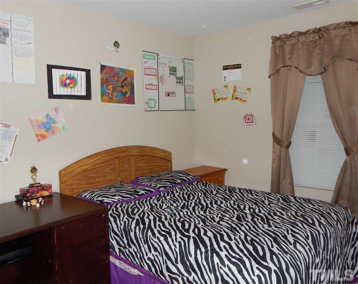 6835 Horseback Lane Raleigh, NC 27610 - Photo 17 of 25 a bedroom with a bed and cabinets