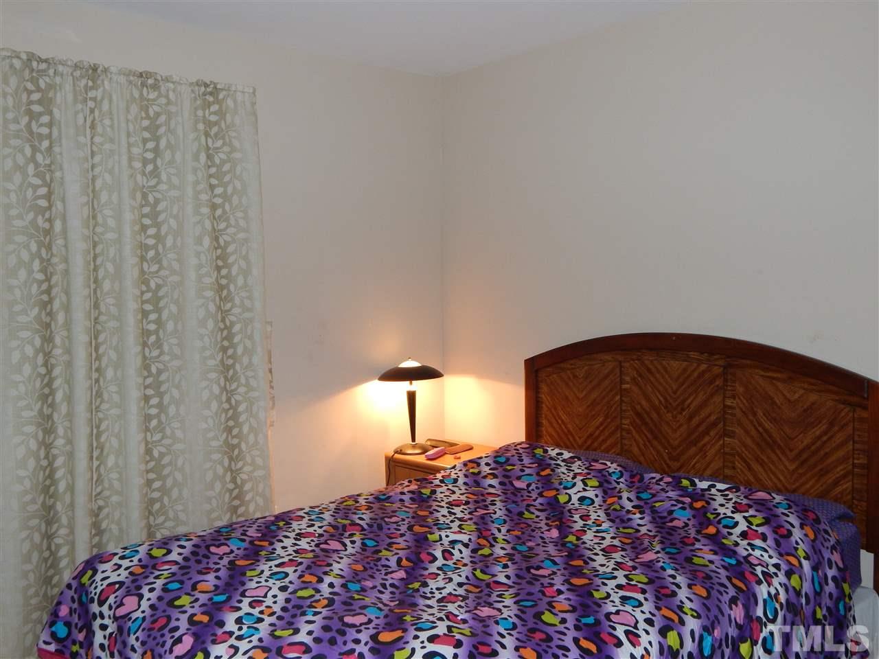 6835 Horseback Lane Raleigh, NC 27610 - Photo 18 of 25 a bedroom with a bed and a lamp