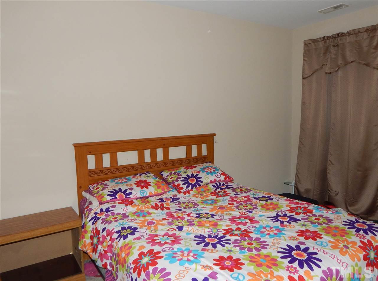 6835 Horseback Lane Raleigh, NC 27610 - Photo 19 of 25 a bedroom with a bed and a wall painting
