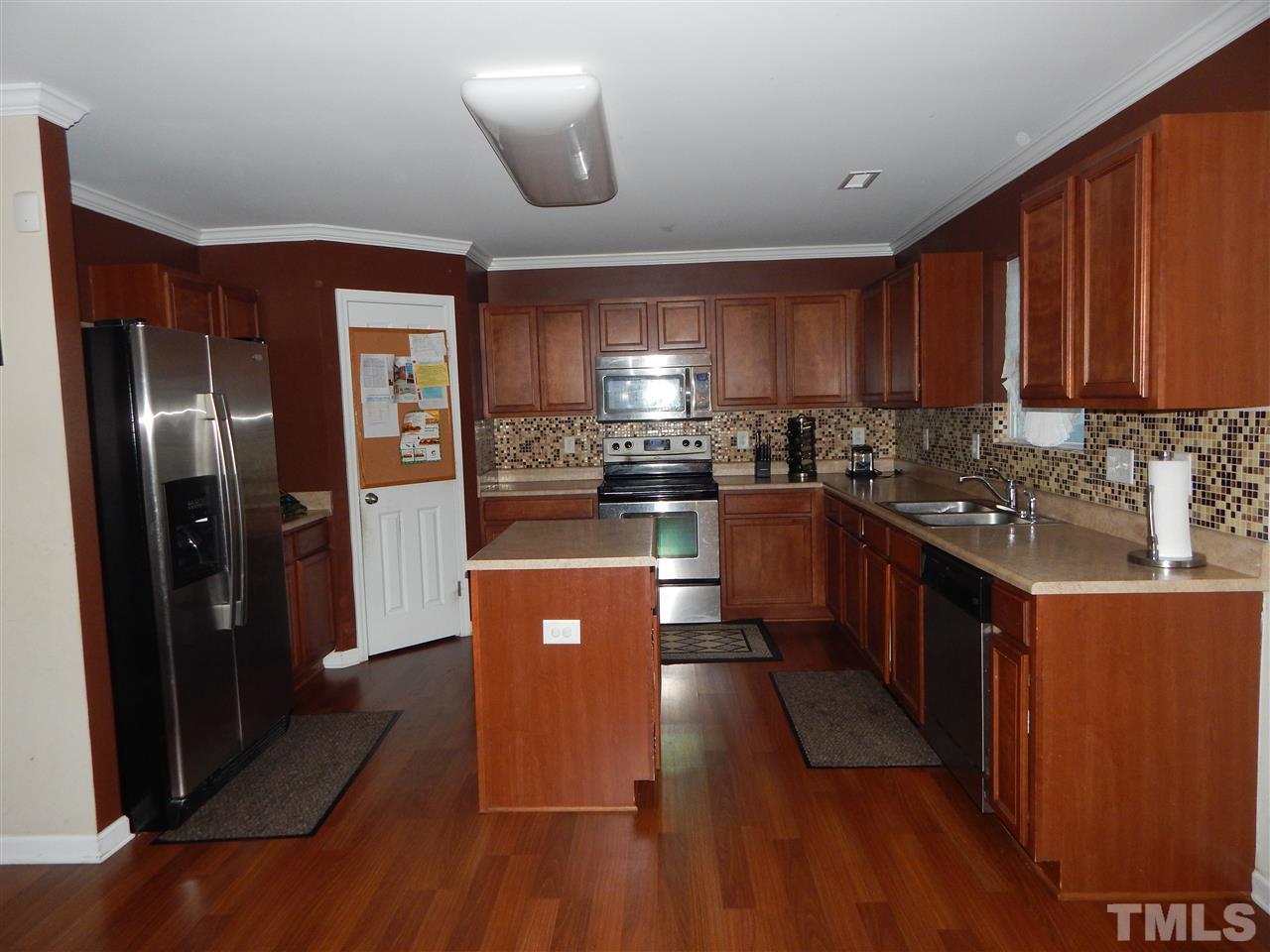 6835 Horseback Lane Raleigh, NC 27610 - Photo 6 of 25 a kitchen with stainless steel appliances granite countertop a refrigerator a sink dishwasher a stove with wooden floor and cabinets