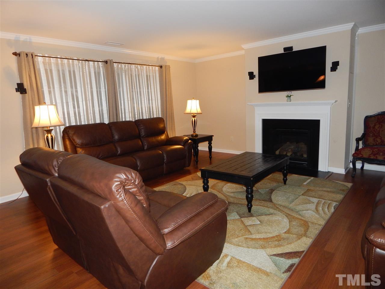 6835 Horseback Lane Raleigh, NC 27610 - Photo 9 of 25 a living room with furniture a flat screen tv and a fireplace