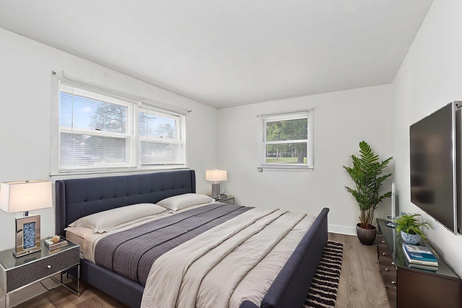 104 High Avenue, Unit C Hampshire, IL 60140 - Photo 13 of 22 a bedroom with a large bed and a flat tv screen on a dresser