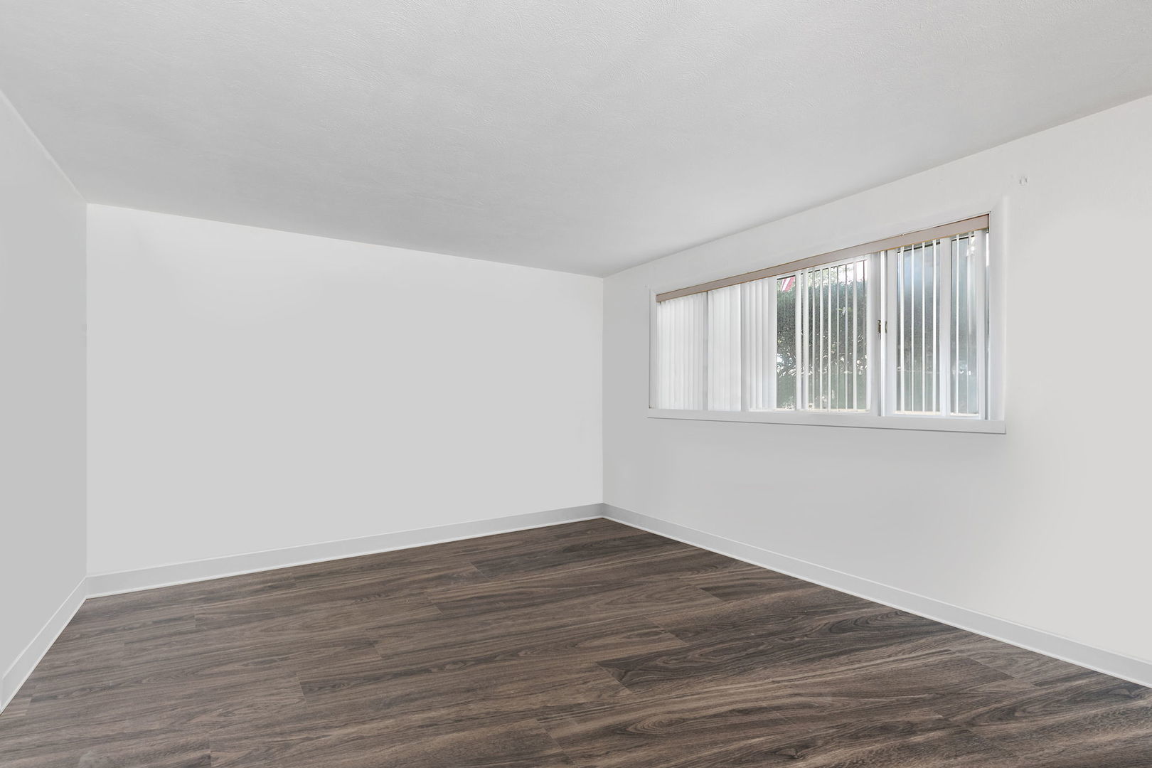104 High Avenue, Unit C Hampshire, IL 60140 - Photo 6 of 22 a view of an empty room with wooden floor and a window