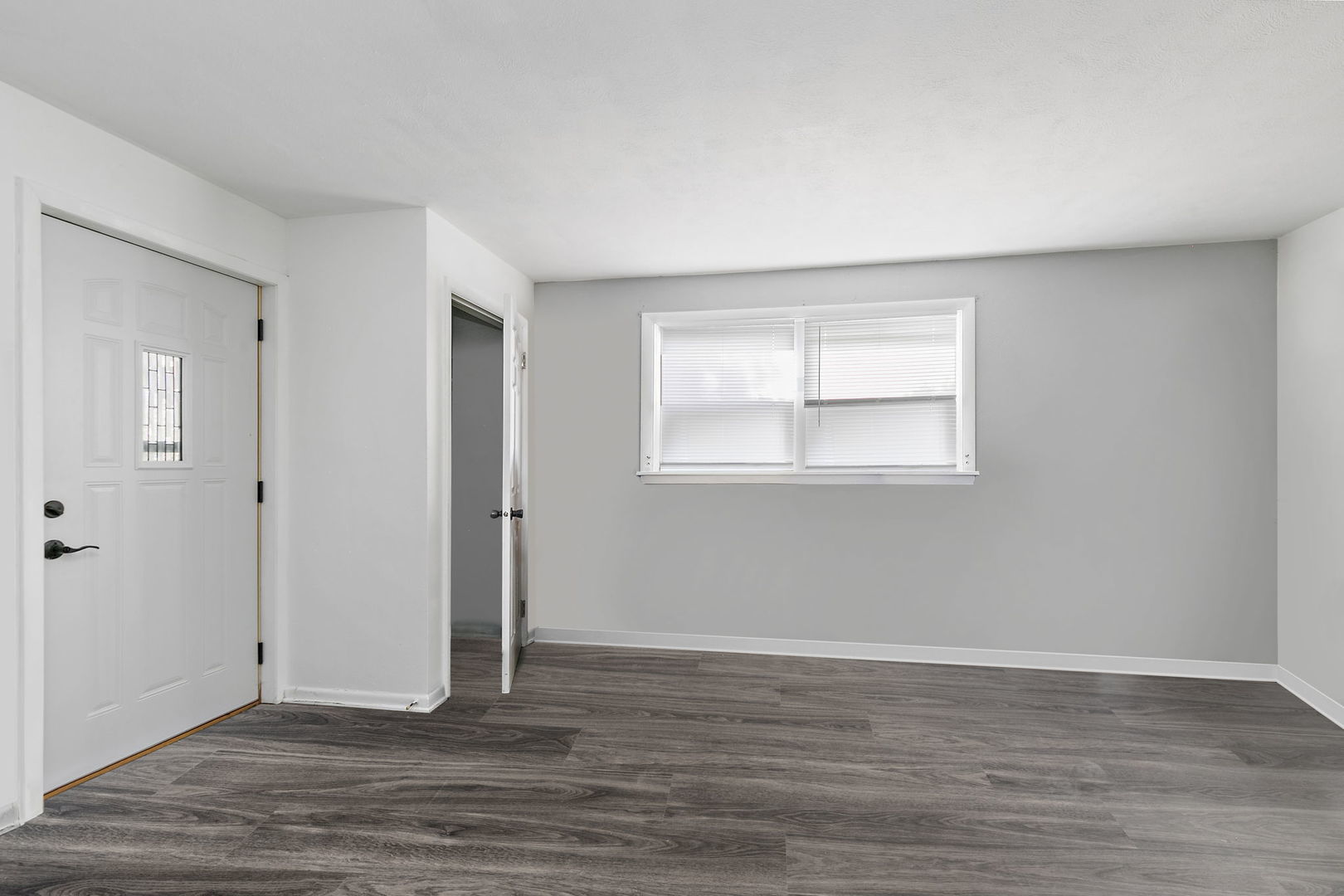 104 High Avenue, Unit C Hampshire, IL 60140 - Photo 8 of 22 a view of an empty room with wooden floor and a window