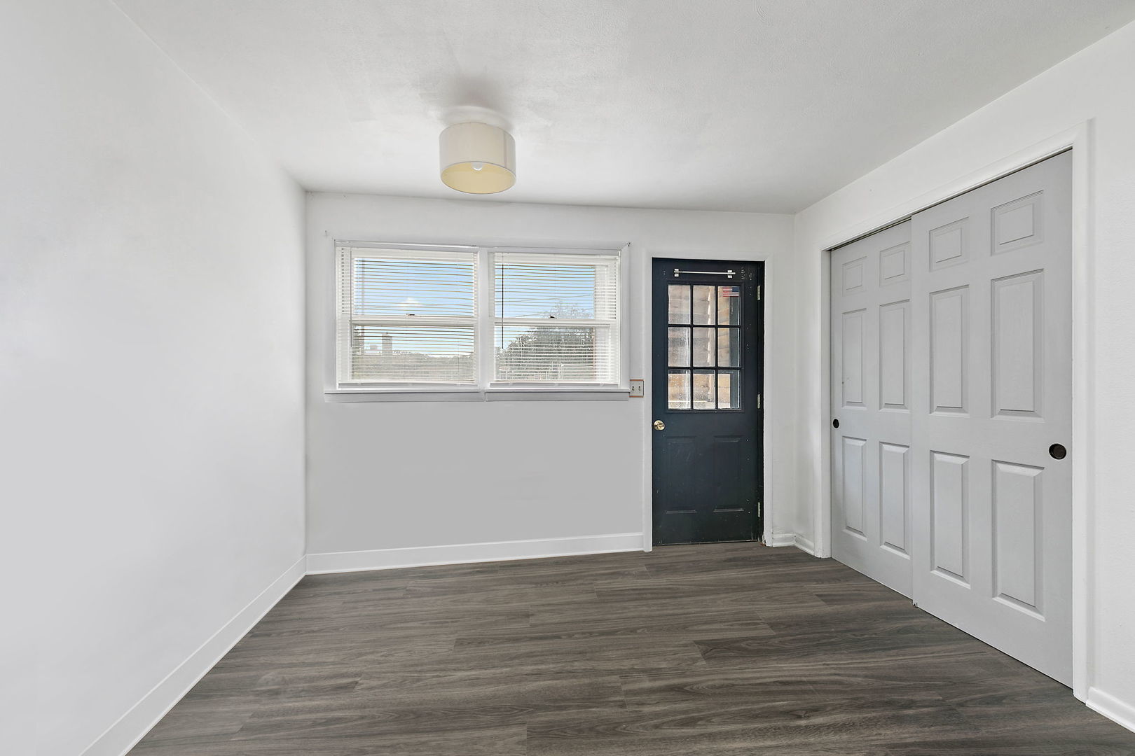 104 High Avenue, Unit C Hampshire, IL 60140 - Photo 10 of 22 an empty room with wooden floor cabinet and windows