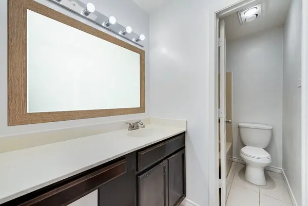 a bathroom with a sink a toilet a mirror and shower