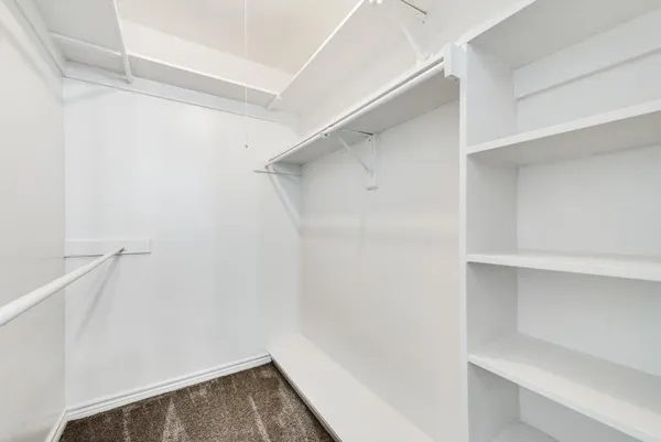 a view of walk in closet with empty racks