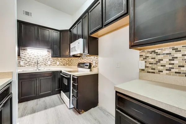 a kitchen with a sink stove and cabinets