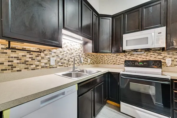 a kitchen with a sink stove and microwave