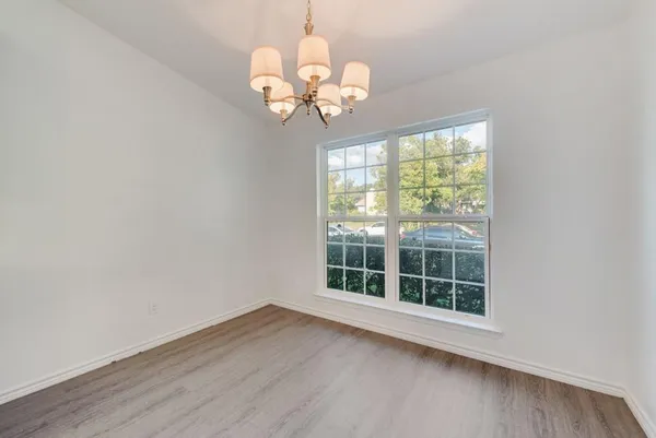 a view of a room with wooden floor and chandelier