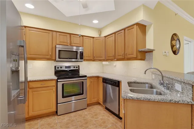 a kitchen with granite countertop a sink stainless steel appliances and cabinets