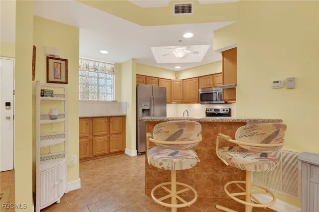 a large kitchen with kitchen island stainless steel appliances a stove refrigerator and microwave