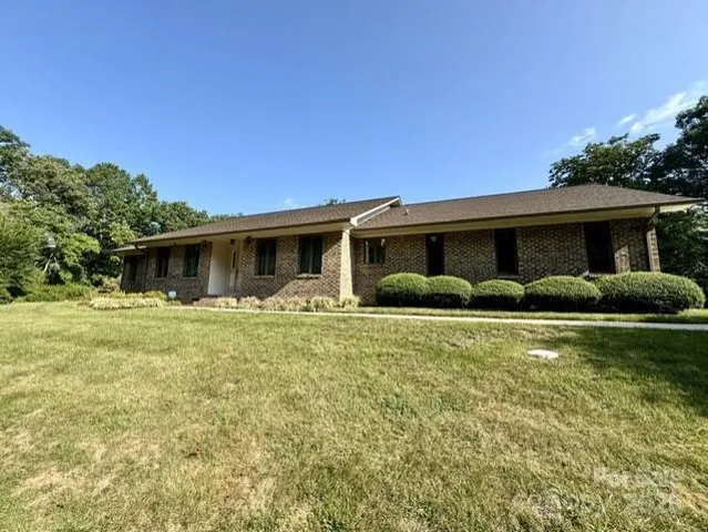 a front view of house with yard barbeque and outdoor seating