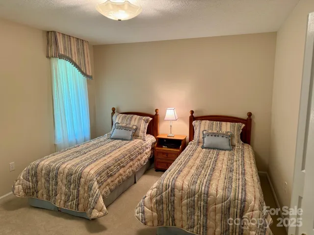 a bedroom with two beds and a chandelier