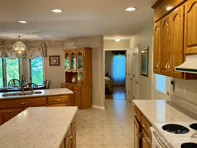 a kitchen with stainless steel appliances kitchen island granite countertop a refrigerator and a sink