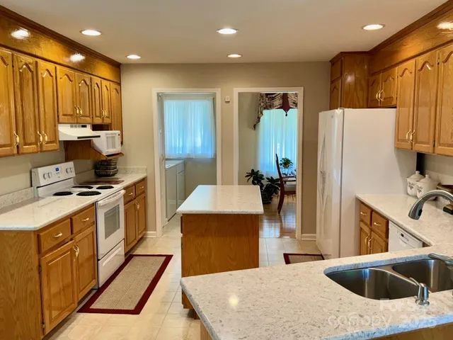 a kitchen with stainless steel appliances kitchen island a stove a sink a refrigerator and cabinets