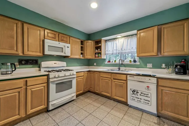 a kitchen with granite countertop cabinets stainless steel appliances a sink and a window