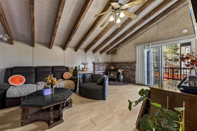 a living room with furniture kitchen view and a chandelier