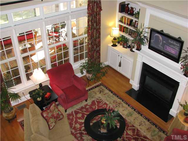 7300 Sparhawk Road Wake Forest, NC 27587 - Photo 8 of 12 2 story family good just off the kitchen, features soaring ceilings, bookshelves and cabinets on either side of the gas log fireplace and windows across one wall (that look into a screened porche) Den/Family/Great Room