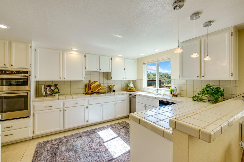 425 Canon Del Sol La Selva Beach, CA 95076 - Photo 12 of 59 a kitchen that has a lot of white cabinets and stainless steel appliances