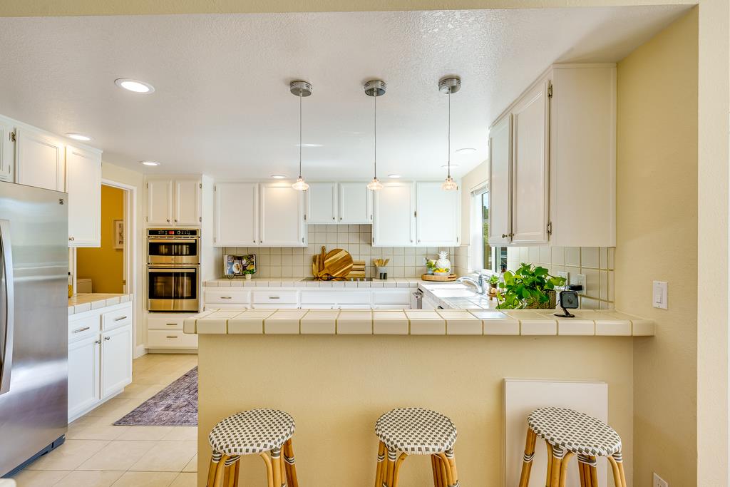 425 Canon Del Sol La Selva Beach, CA 95076 - Photo 15 of 59 a kitchen with stainless steel appliances kitchen island granite countertop a table and chairs in it