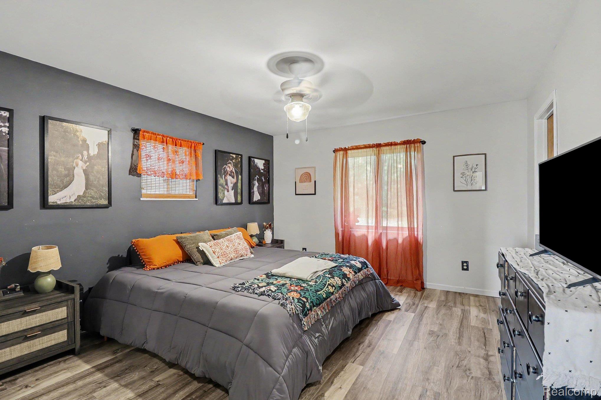 2905 German Road Columbiaville, MI 48421 - Photo 16 of 31 Bedroom with wood-finish flooring, a ceiling fan with integrated lighting, and a neutral color palette