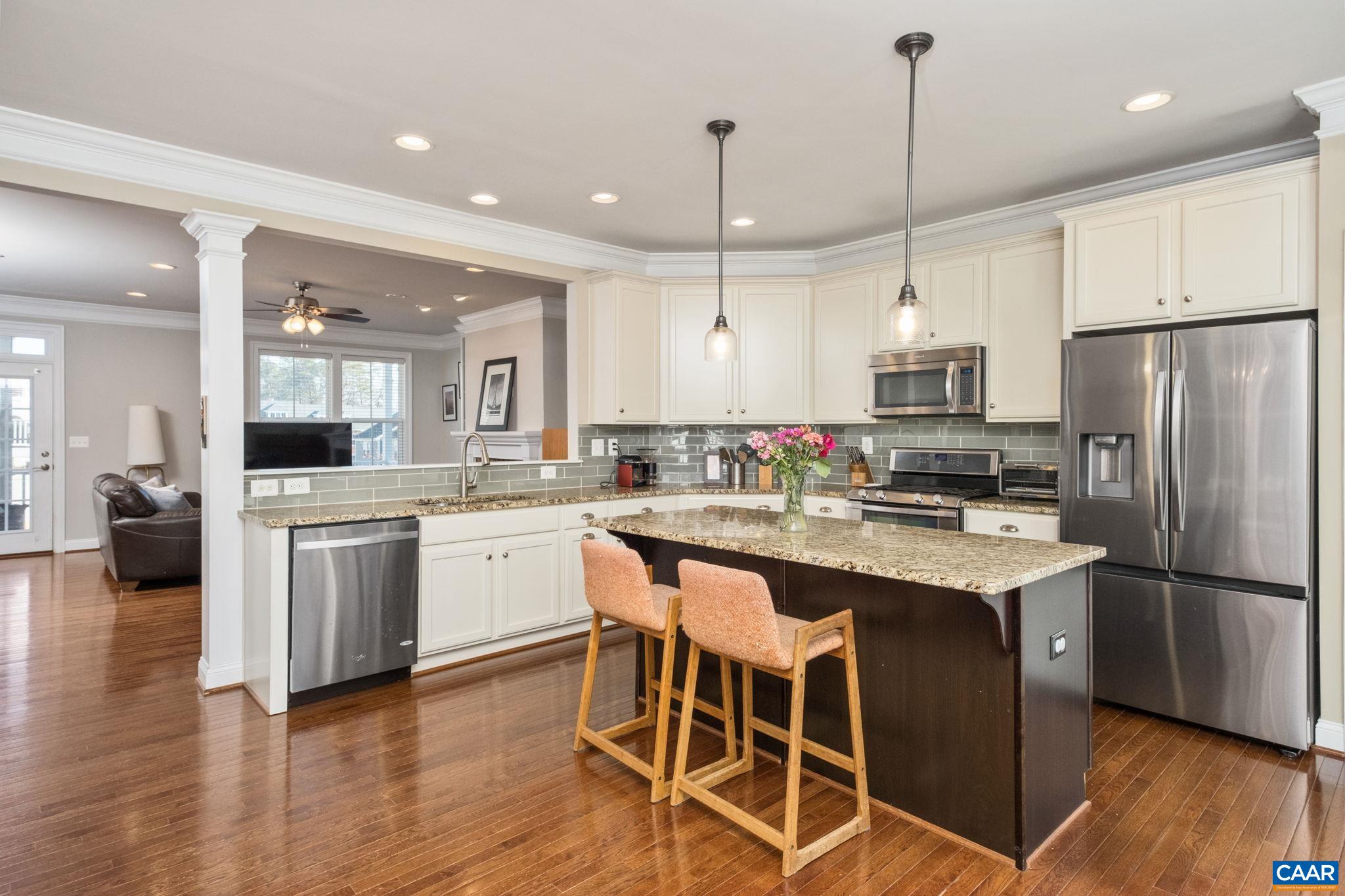 2138 Avinity Loop Charlottesville, VA 22902 - Photo 11 of 49 a kitchen with stainless steel appliances kitchen island granite countertop a refrigerator a stove a sink and white cabinets with wooden floor