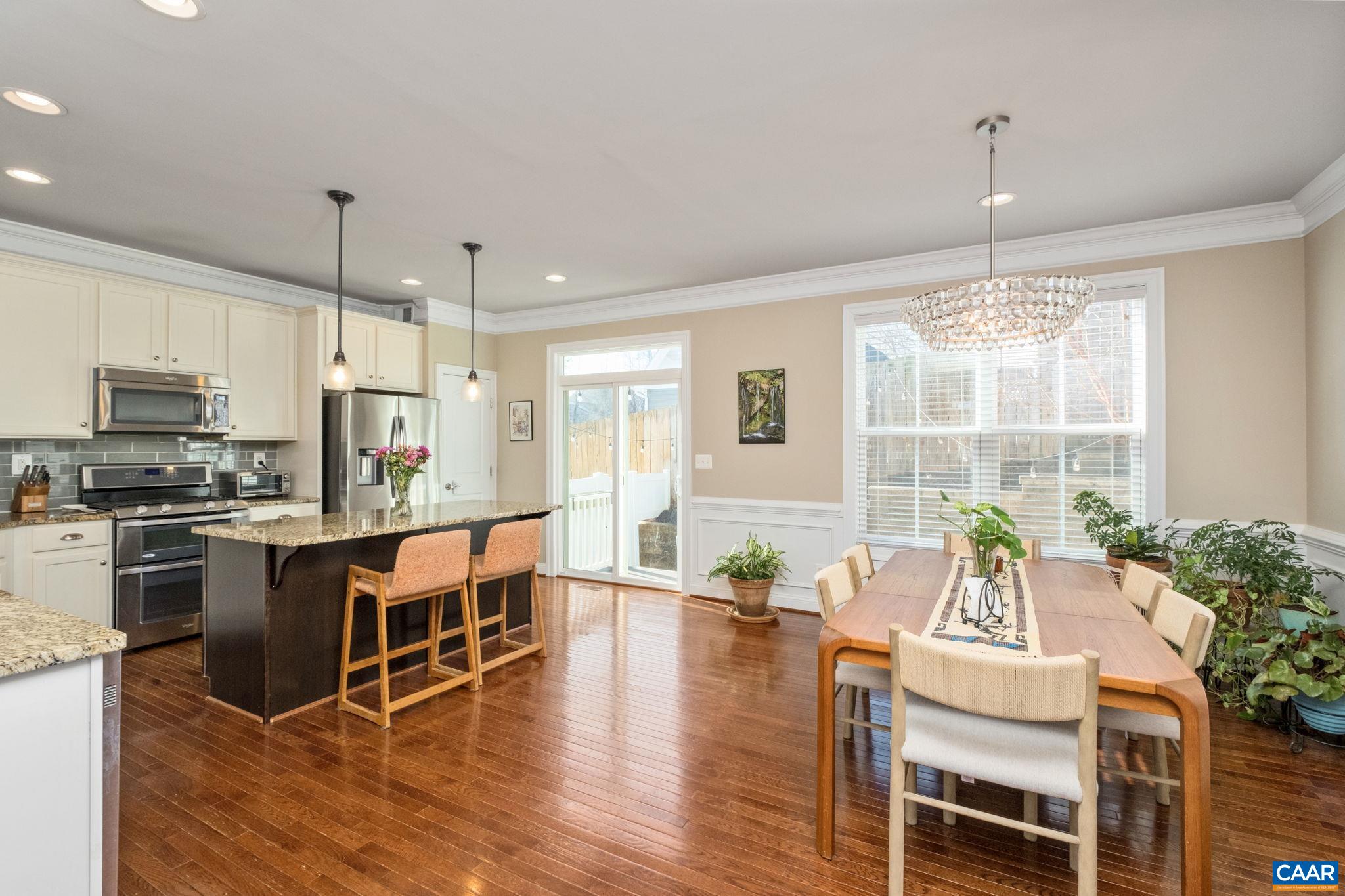 2138 Avinity Loop Charlottesville, VA 22902 - Photo 10 of 49 a kitchen with granite countertop a stove a sink a dining table and chairs