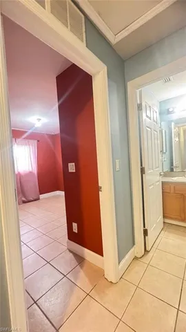 a view of a hallway with wooden cabinets