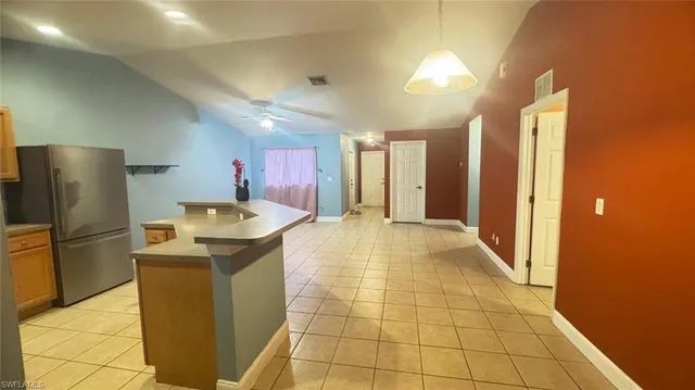 a kitchen with a sink a refrigerator and cabinets
