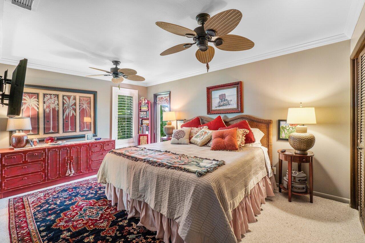 33 Ocean Drive Jupiter Inlet Colony, FL 33469 - Photo 24 of 30 a bedroom with a bed and a chandelier