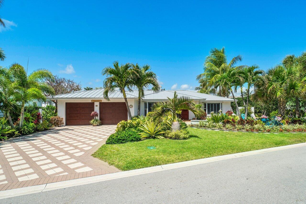 33 Ocean Drive Jupiter Inlet Colony, FL 33469 - Photo 10 of 30 a front view of a house with a yard and potted plants