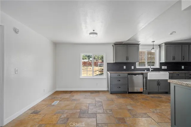 a kitchen with granite countertop a stove a sink and a window