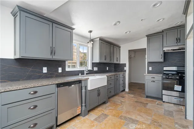 a kitchen with stainless steel appliances granite countertop a stove sink and cabinets