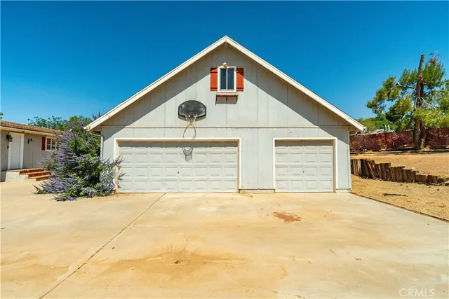 a front view of house with yard and trees in the background