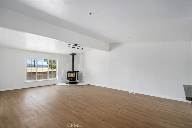 a view of a livingroom with wooden floor a fireplace and window