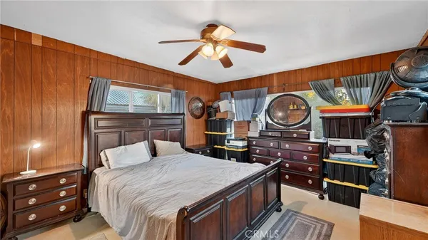 a bedroom with a bed a dresser and chair