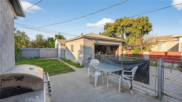 a backyard of a house with table and chairs