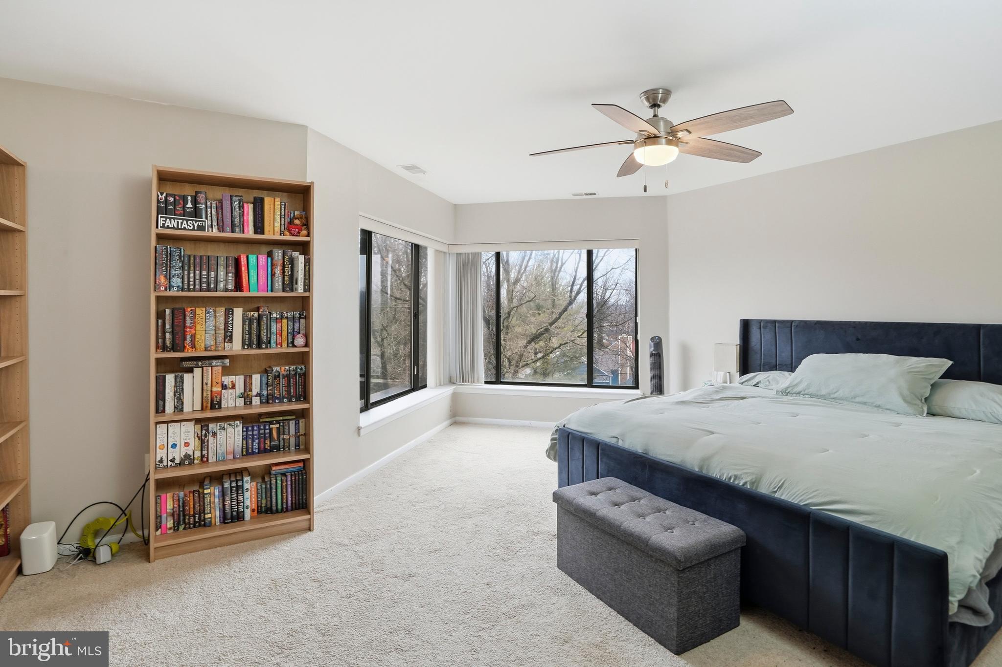 3021 Fallstaff Road, Unit 502B Baltimore, MD 21209 - Photo 15 of 39 a spacious bedroom with a bed a dresser and a book shelf