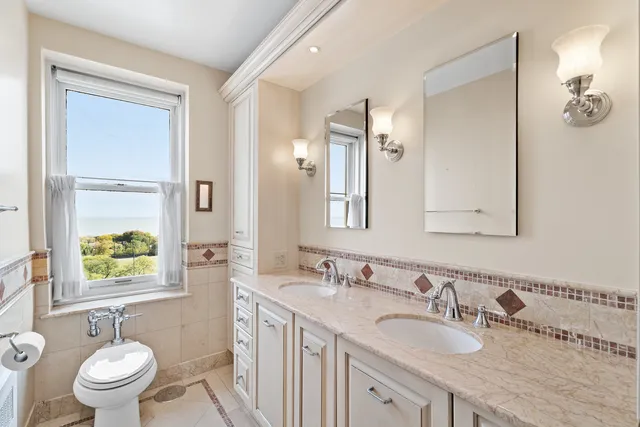 a bathroom with a toilet shower vanity and a sink