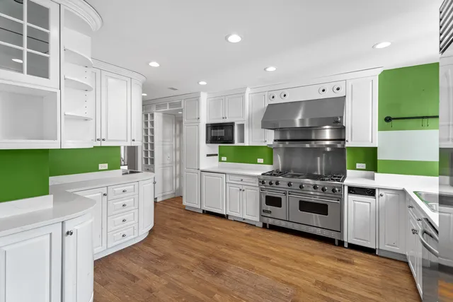 a kitchen with white cabinets and stainless steel appliances