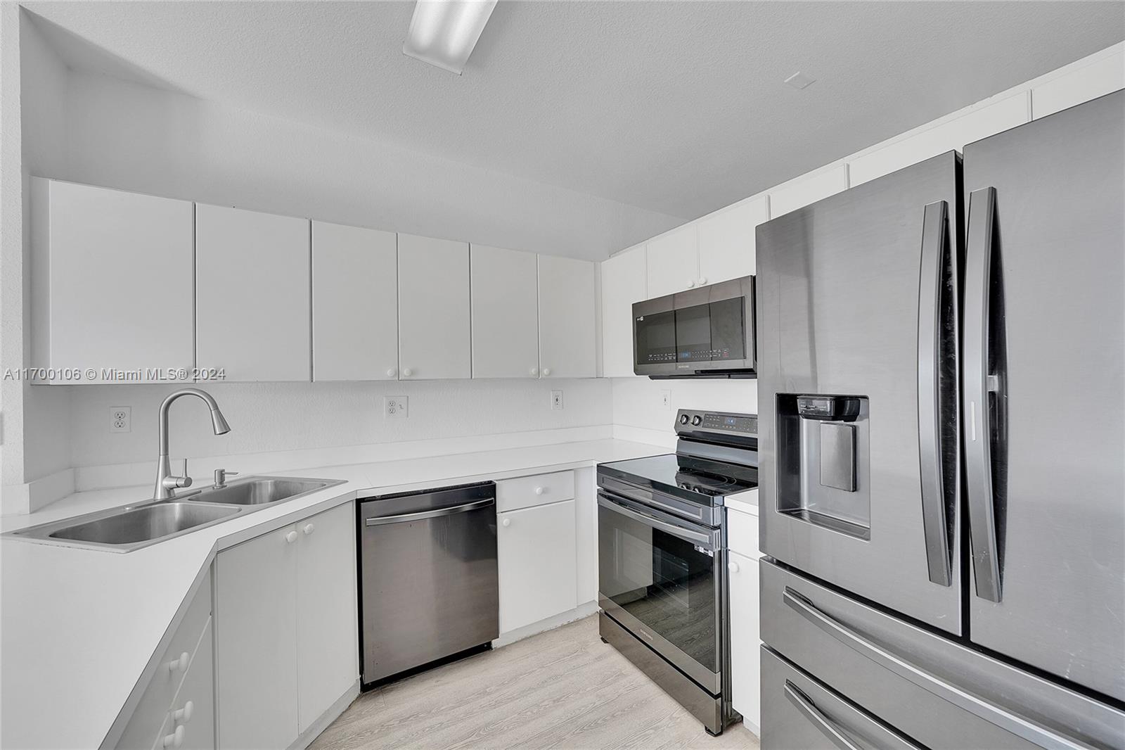 a kitchen with a refrigerator sink and microwave