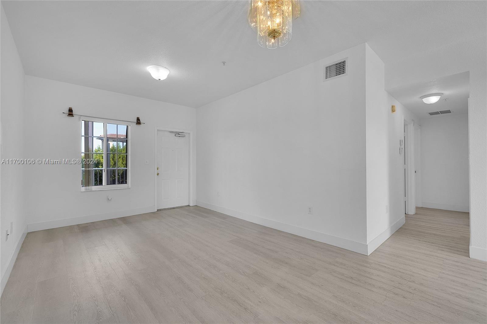 6940 Northwest 179th Street, Unit 3057 Hialeah, FL 33015 - Photo 26 of 32 an empty room with windows and entrance