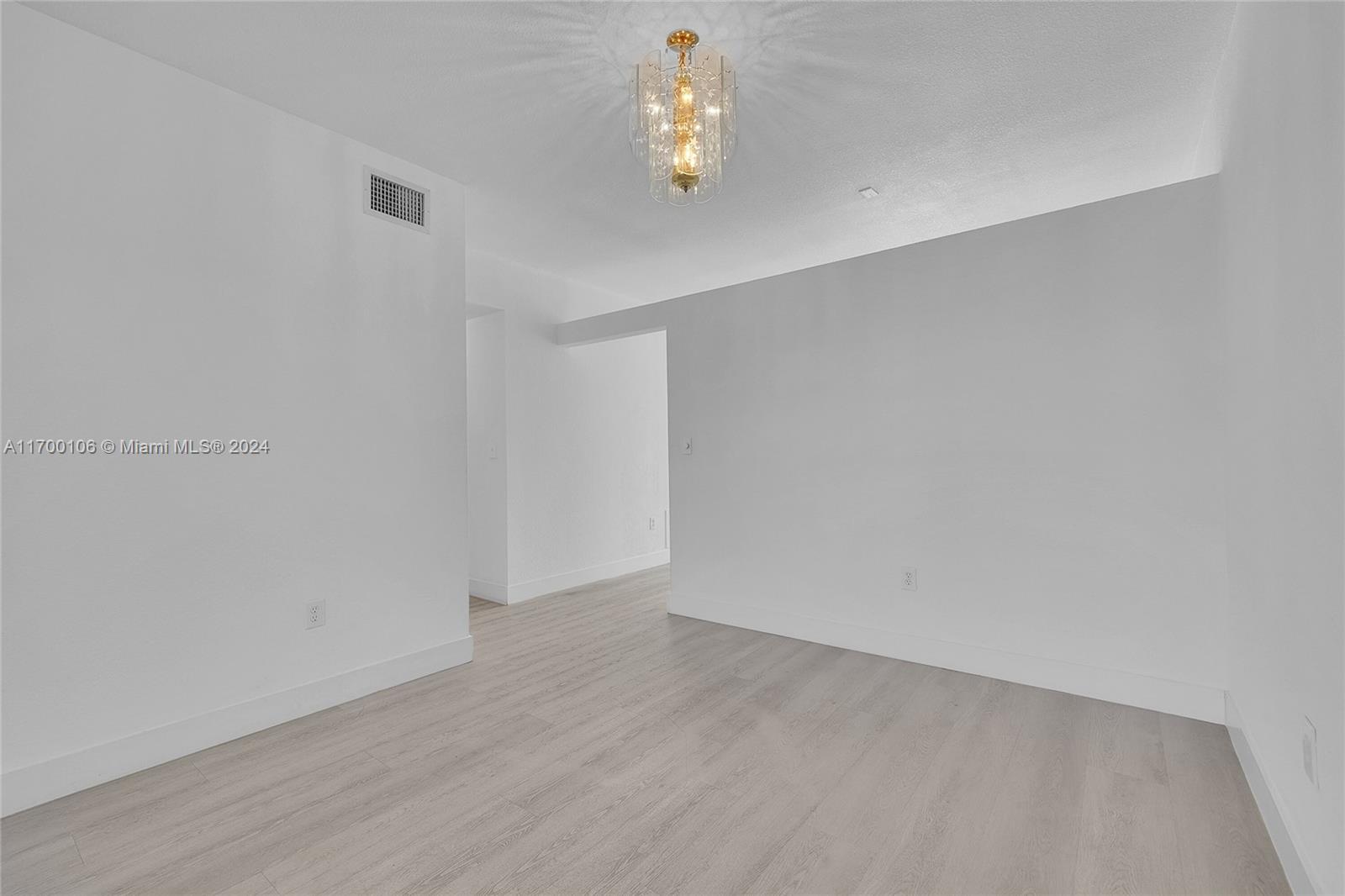6940 Northwest 179th Street, Unit 3057 Hialeah, FL 33015 - Photo 27 of 32 a view of an empty room with wooden floor and window