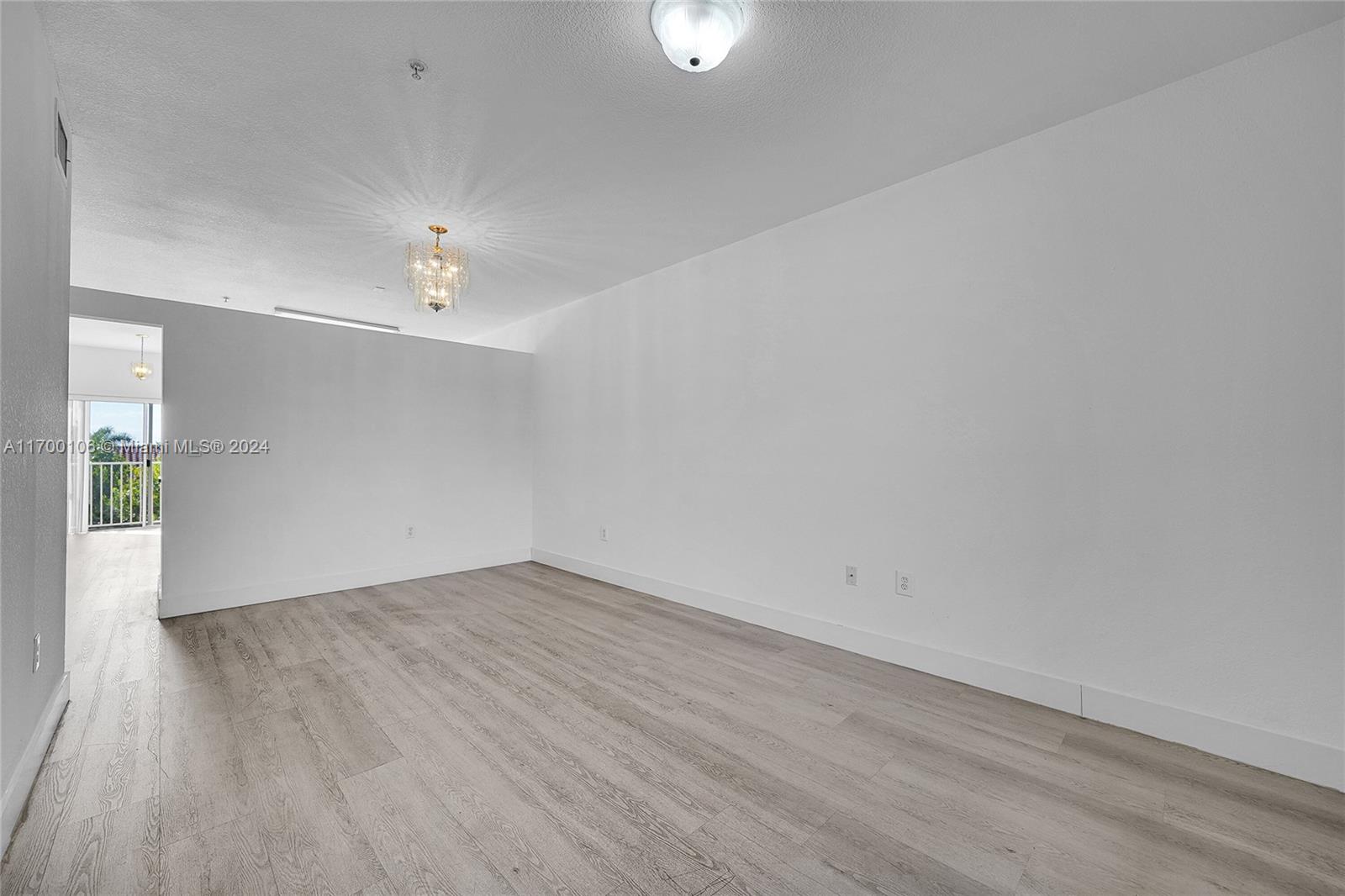 6940 Northwest 179th Street, Unit 3057 Hialeah, FL 33015 - Photo 29 of 32 a view of an empty room with wooden floor